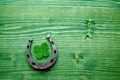 Four-leaved clover and a horse shoe on green wooden background. St. Patrick`s day Royalty Free Stock Photo