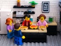 Four Lego minifigures in a kitchen and making pizzas