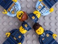 Four Lego police officers on gray baseplate background