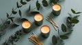 Four lit candles with eucalyptus branches and matches on a dusty blue background, AI generated Royalty Free Stock Photo