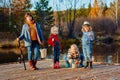 Four little girls catch fish on a wooden pontoon.Weekend at the lake. Fishing with friends.