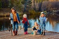 Four little girls catch fish on a wooden pontoon.Weekend at the lake. Fishing with friends. Royalty Free Stock Photo