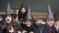 Four little girls dressed as witches, zombies, skeleton and make-up look intimidating at the camera. Slow motion.