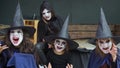 Four little girls dressed as witches, zombies, skeleton and make-up look intimidating at the camera. Slow motion