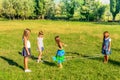 Four little girls playing elastics in the park