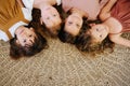 Four little girls about the same age lying on the floor head to head Royalty Free Stock Photo