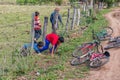 Four little Paraguayan boys crawl under a fence to their bicycles.