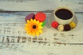 Macaroons, coffee, baals and flower on a table. Royalty Free Stock Photo