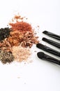 Four makeup brushes and crumbled eyeshadows of different colors