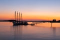 Four-mast sailboat anchored at the pier in Frenchman Bay during a pink and orange sunrise