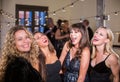 Four Women Laughing Loudly at a Party