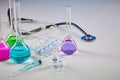 Four medical flasks with colorful chemical reagents. Seven mockup ampoules with liquid, syringe and phonendoscope Royalty Free Stock Photo