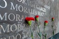 Memorial flowers lay against the names of the victims Royalty Free Stock Photo