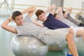 Four men leaning on aerobic balls twisting towards camera