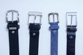 Four metal buckles male black leather and blue on white background close-up