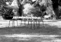 four metal chairs standing on grass for people to relax in forest