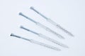 Four metal dowel-nail with  plastic box on a white background Royalty Free Stock Photo