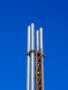 Four metal pipes against a blue sky