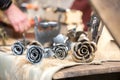 Four metal roses of silver and gold color on the table at the seasonal fair of masters