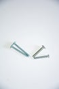 Four metal screws are arranged in a staggered manner, with a pure white background highlighting the simple texture of the hardware Royalty Free Stock Photo