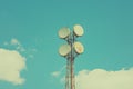 Four microwave antennas transmitting data on a rusty metal tower against a blue sky Royalty Free Stock Photo