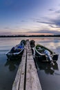 Four moored boats at sunset near a wooden pier. Vertical view of