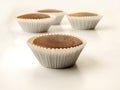 Four muffins with their respective capsules seen frontally Royalty Free Stock Photo