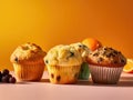 Four muffins on a yellow background with oranges and grapes Royalty Free Stock Photo