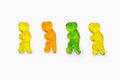 Four multi-colored dinosaur shaped gummy candies on a white background