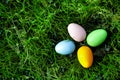 Four multi-colored Easter eggs lie in the green grass Royalty Free Stock Photo