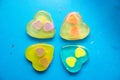 Four multi-colored handmade soaps in the form of a heart on a blue background Royalty Free Stock Photo