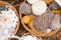 Four multi-colored woolen threads, rolls of beige and gray cotton lace, wooden beads in wicker rattan baskets, hobbies