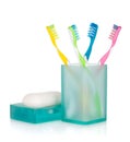 Four multicolored toothbrushes and soap