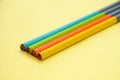 The four multicolour wooden pencils isolated in yellow background