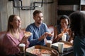 Four multiethnic best friends eat pizza drink coffee in cafe Royalty Free Stock Photo