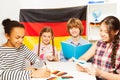 Four multiethnic students studying German at class