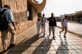 Four muslim boys walking on a sidewalk outside a Metro station in the city of