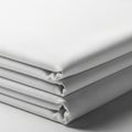 Four neatly folded white fabric sheets stacked on top of each other. The fabric appears smooth and Royalty Free Stock Photo