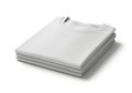 Four neatly folded white T-shirts stacked on a white surface. The garments are perfe Royalty Free Stock Photo