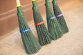 Four new brooms made of green plastic.