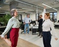 Four office workers warm up during a break. Employees do fitness exercises at the workplace.