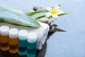 Four oil bottles for body with spa tropical flower, towel and leaves Royalty Free Stock Photo