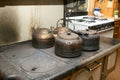 Four old blackened metal kettles on a stove Royalty Free Stock Photo