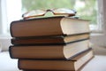 Four old books and eyeglasses near window. Knowledge education concept Royalty Free Stock Photo