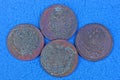 Four old brown coins lie on a blue table Royalty Free Stock Photo