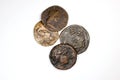 Four old coins with portraits on a white background