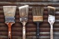 Four Old Crusty Household Paintbrushes on Rusted Corrugated Metal Background