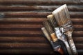 Four Old Dirty Crusty Household Paintbrushes Stacked On Each Other Rusted Corrugated Metal Background