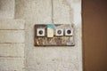Four old door bell buttons on concrete wall near door Royalty Free Stock Photo