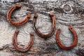 Four old rusty horseshoes on wooden ground Royalty Free Stock Photo
